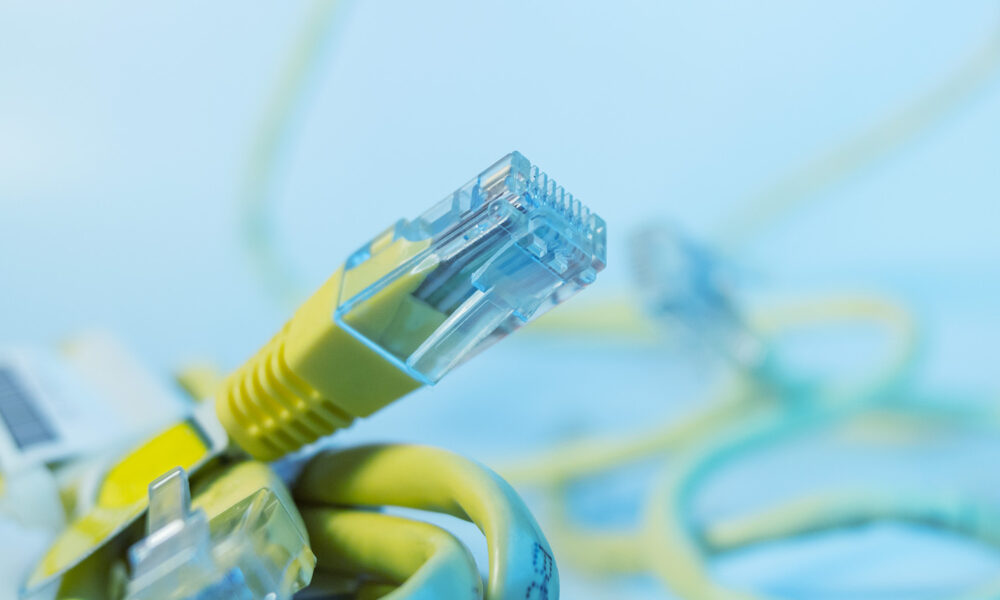 up-close photograph of a yellow Ethernet cable connection point