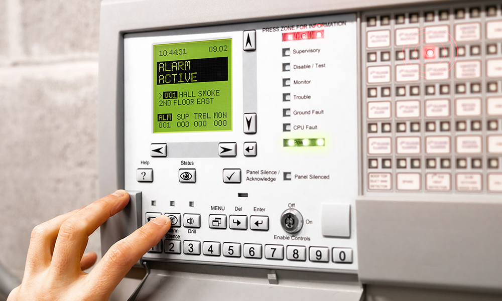 Photograph of an alarm panel. Alarm shows as active with smoke detector connected.
